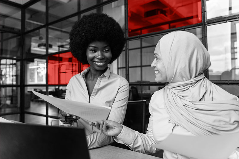African American woman and woman in a hijab at work.